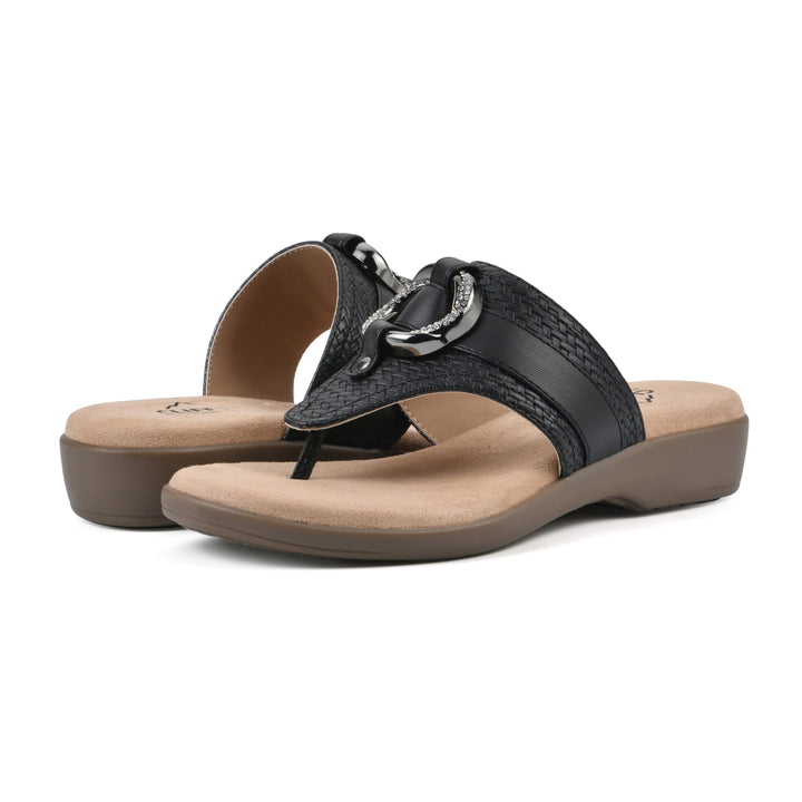 Angle view of a pair of black thong sandals with a centered metal ring ornament and tan sole