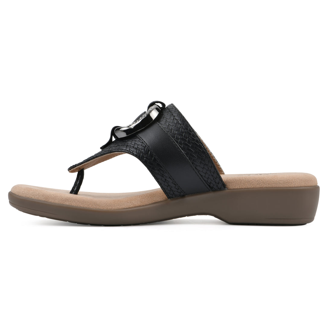 Side view of a black thong sandal with a centered metal ring ornament and tan sole