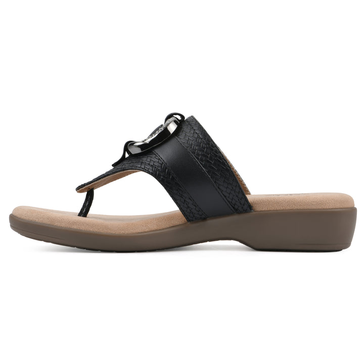 Side view of a black thong sandal with a centered metal ring ornament and tan sole