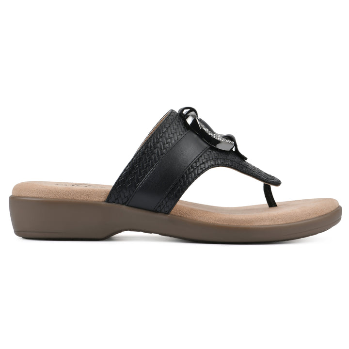 Side view of a black thong sandal with a centered metal ring ornament and tan sole