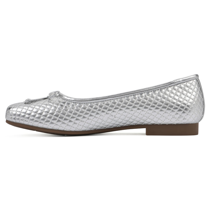 Side view of a silver quilted pattern flat with small, centered, silver bow and a brown sole