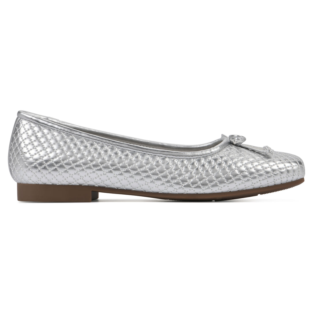 Side view of a silver quilted pattern flat with small, centered, silver bow and a brown sole