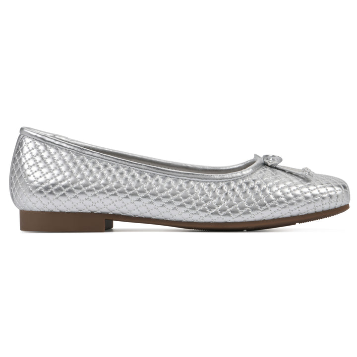 Side view of a silver quilted pattern flat with small, centered, silver bow and a brown sole