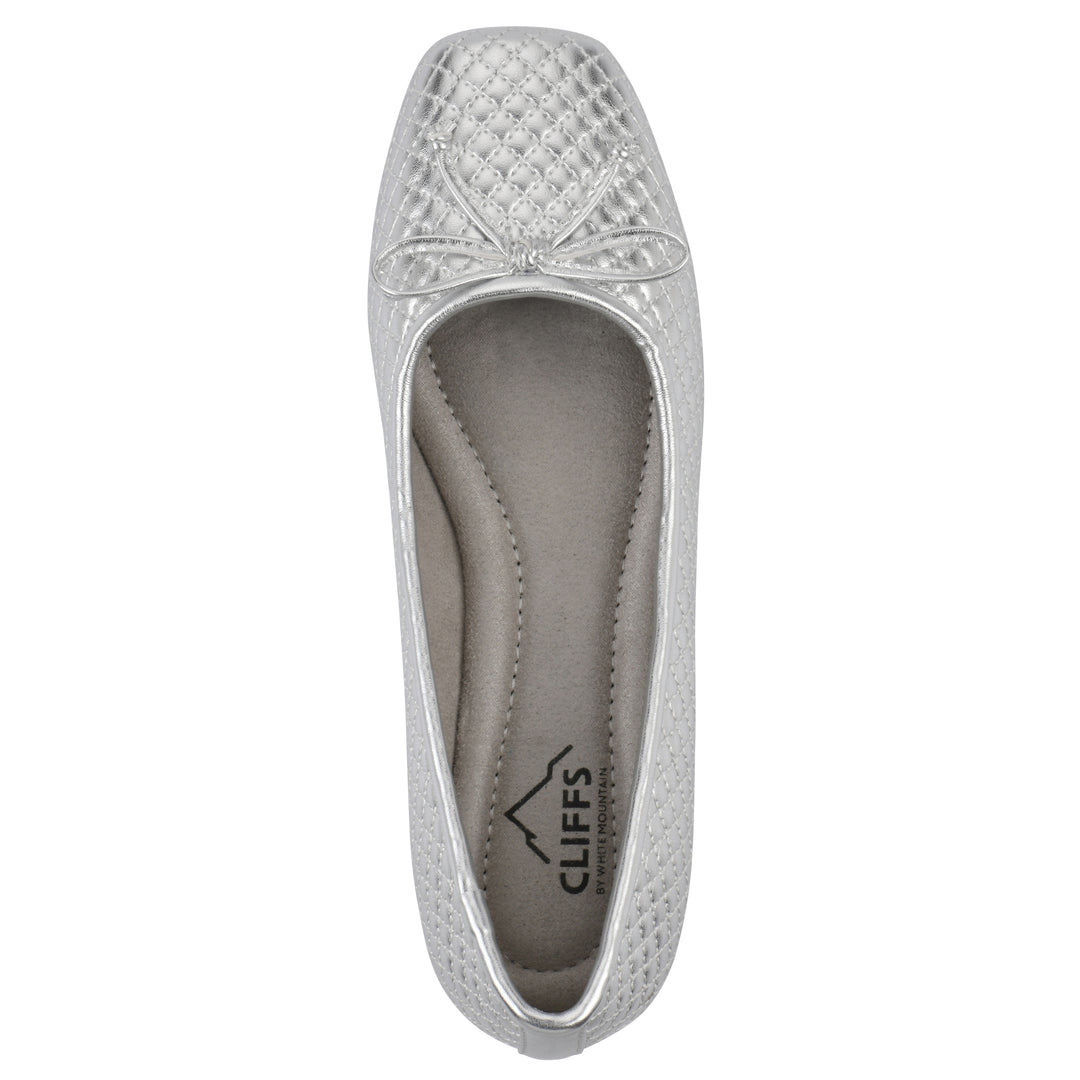 Top view of a silver quilted pattern flat with small, centered, silver bow and a brown sole