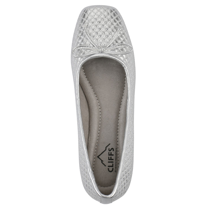 Top view of a silver quilted pattern flat with small, centered, silver bow and a brown sole
