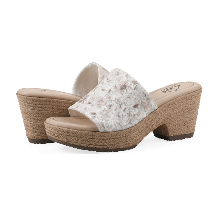 Angle view of a pair of soft white floral designed wedge sandals with a braided rope-style sole