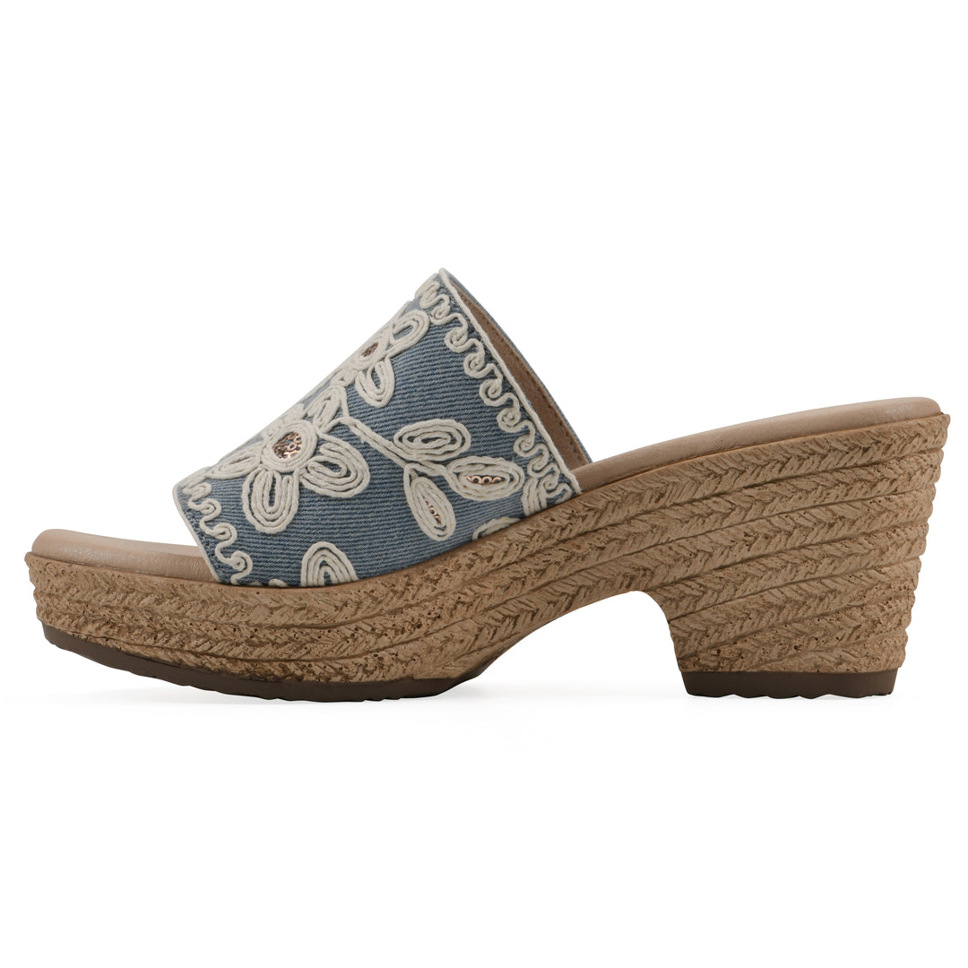 Side view of a denim wedge sandal with cream embroidered floral pattern and a braided rope-style sole