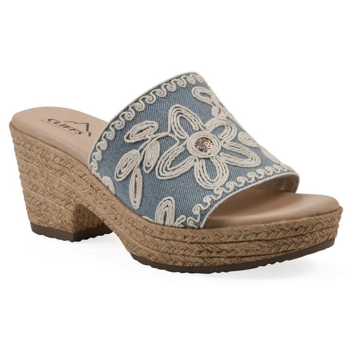 Angle view of a denim wedge sandal with cream embroidered floral pattern and a braided rope-style sole