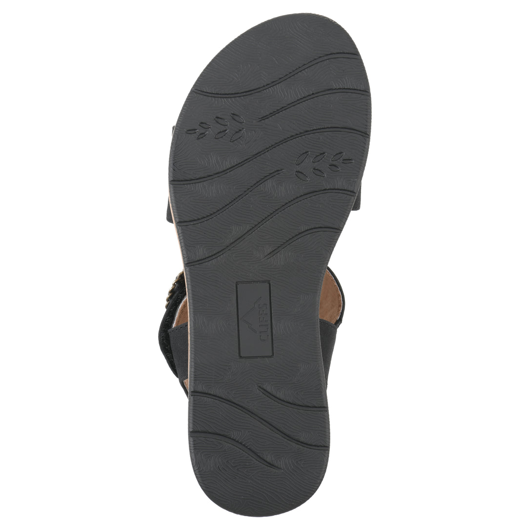 Sole view of a black sandal with double adjustable straps, circular buckle embellishment, and low cork print wedge 