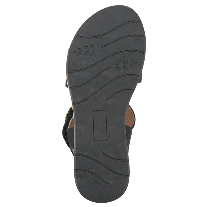 Sole view of a black sandal with double adjustable straps, circular buckle embellishment, and low cork print wedge 