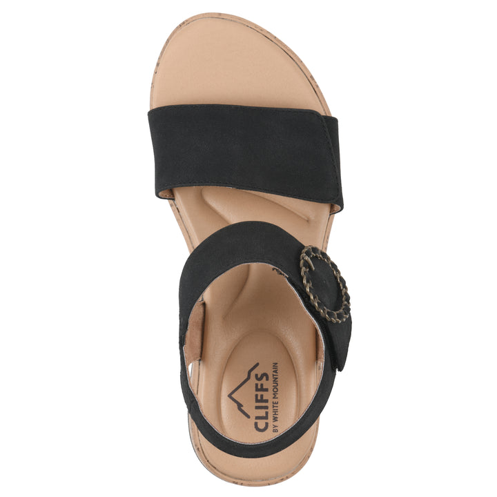 Top view of a black sandal with double adjustable straps, circular buckle embellishment, and low cork print wedge 