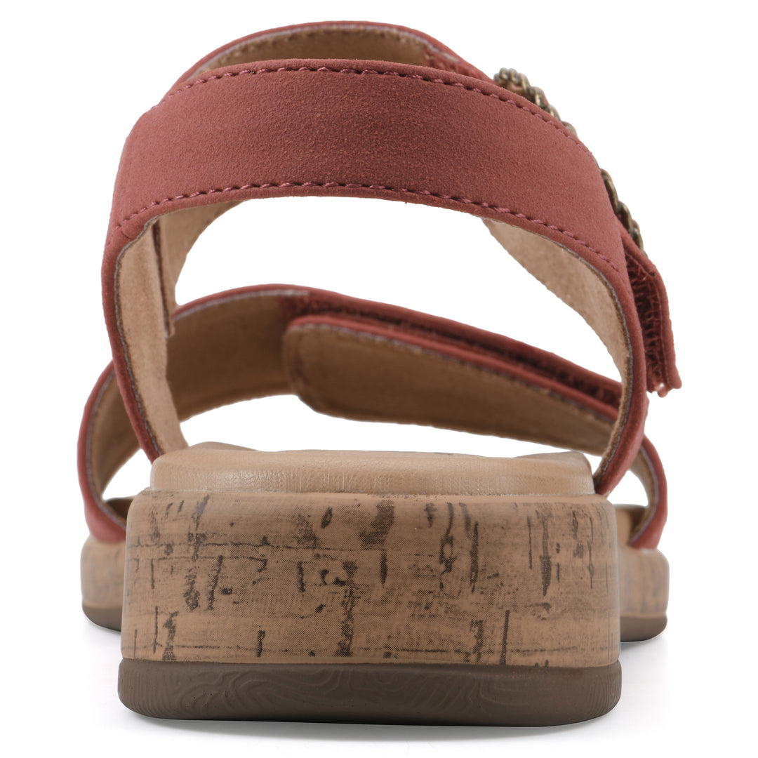 Rear view of a dusty orange sandal with double adjustable straps, circular buckle embellishment, and low cork print wedge 