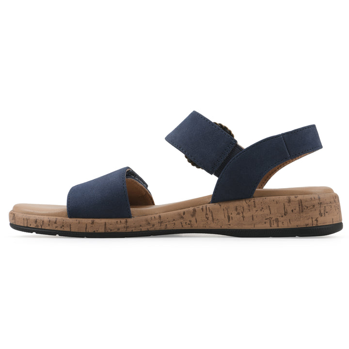 Side view of a dark blue sandal with double adjustable straps, circular buckle embellishment, and low cork print wedge 