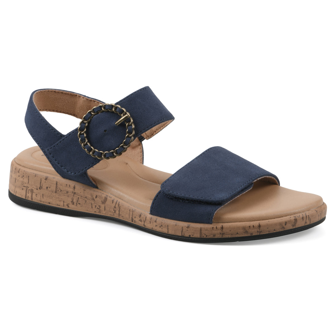 Angle view of a dark blue sandal with double adjustable straps, circular buckle embellishment, and low cork print wedge 
