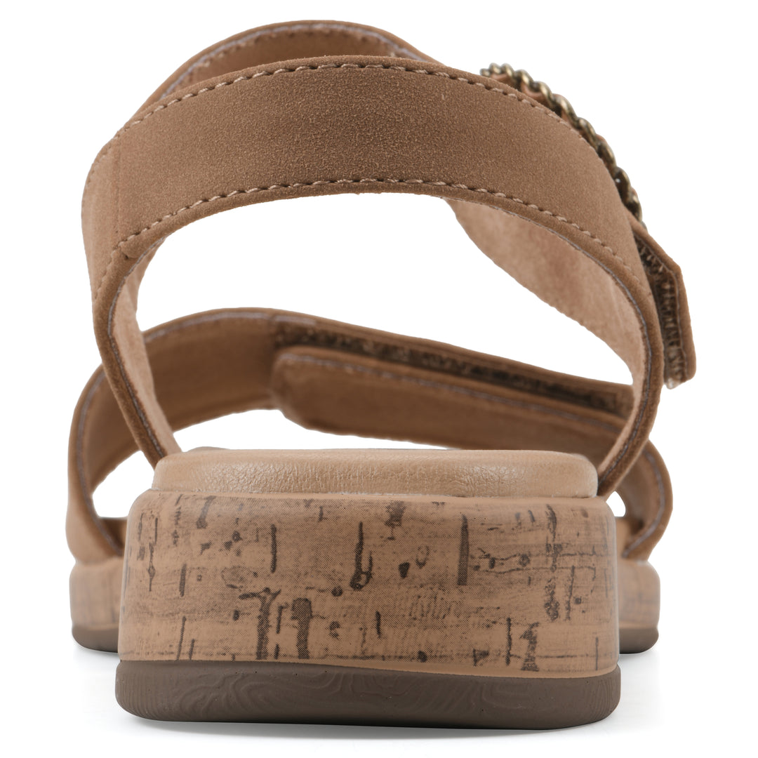 Rear view of a tan sandal with double adjustable straps, circular buckle embellishment, and low cork print wedge 