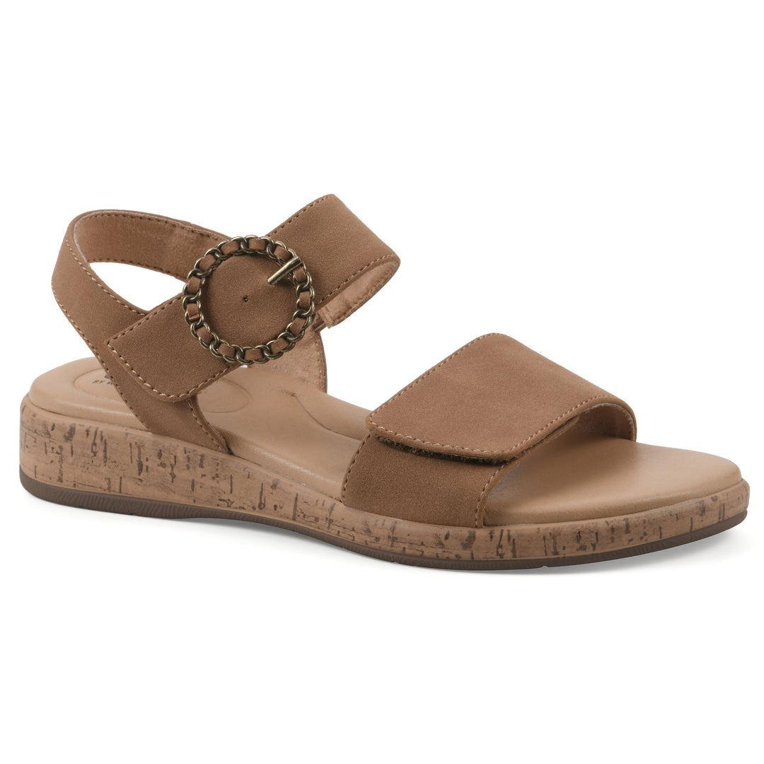 Angle view of a tan sandal with double adjustable straps, circular buckle embellishment, and low cork print wedge 