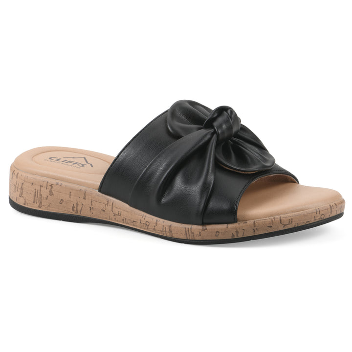 Angle view of a black faux leather sandal with centered twist, and cork-print sole design