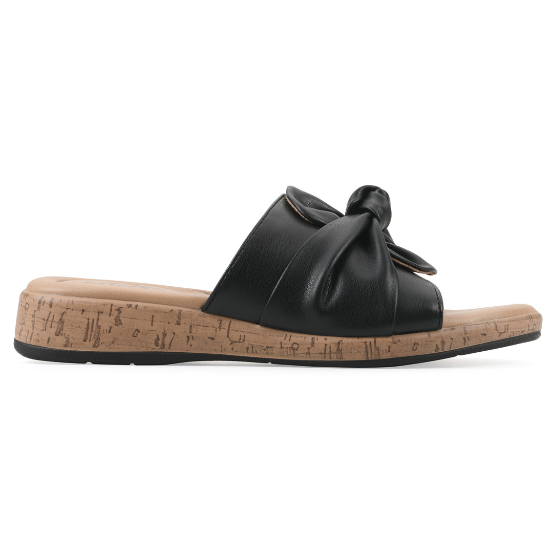 Side view of a black faux leather sandal with centered twist, and cork-print sole design