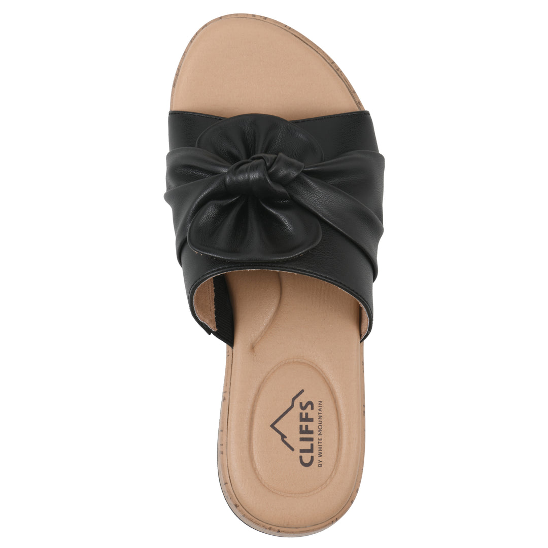 Top view of a black faux leather sandal with centered twist, and cork-print sole design