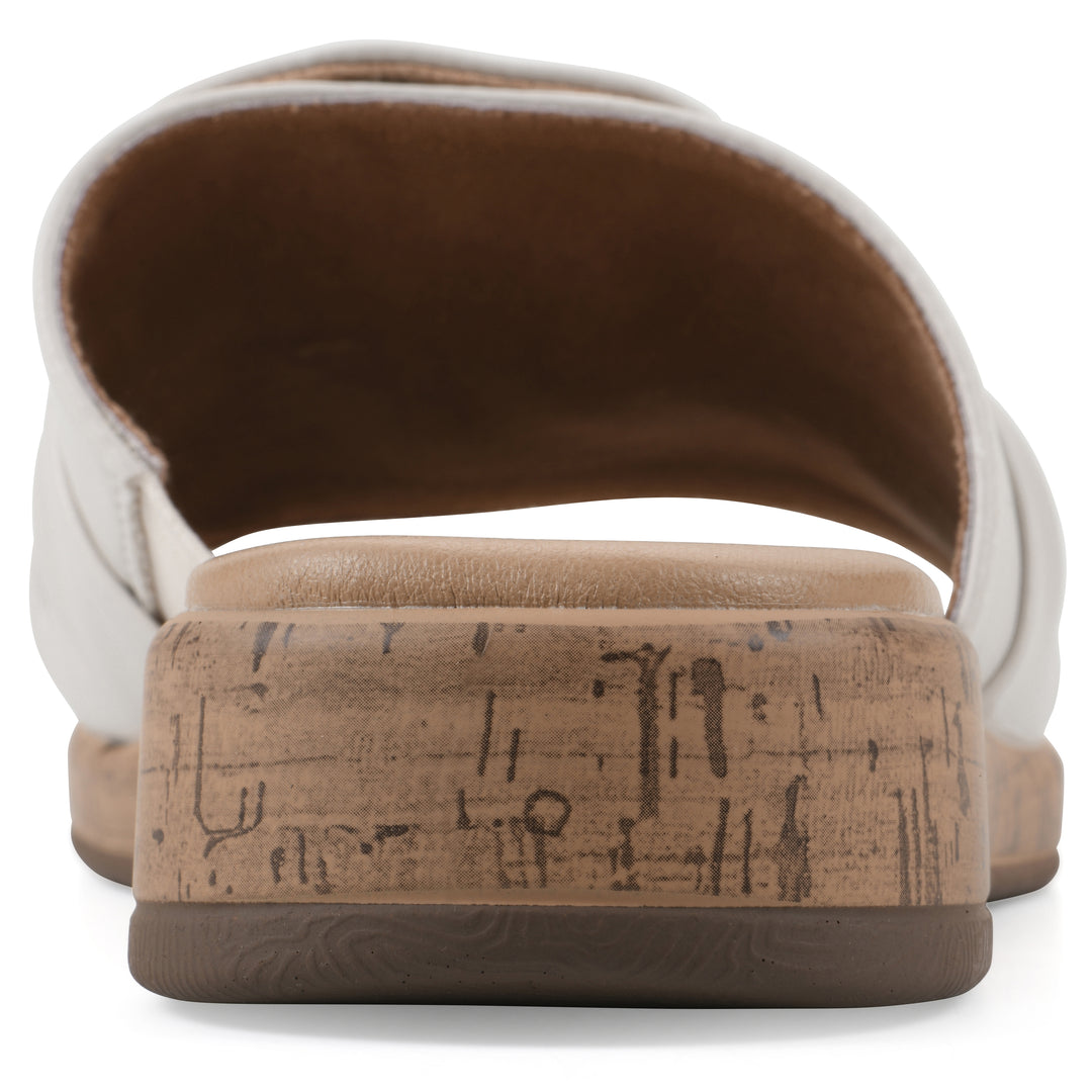 Rear view of a white faux leather sandal with centered twist, and cork-print sole design