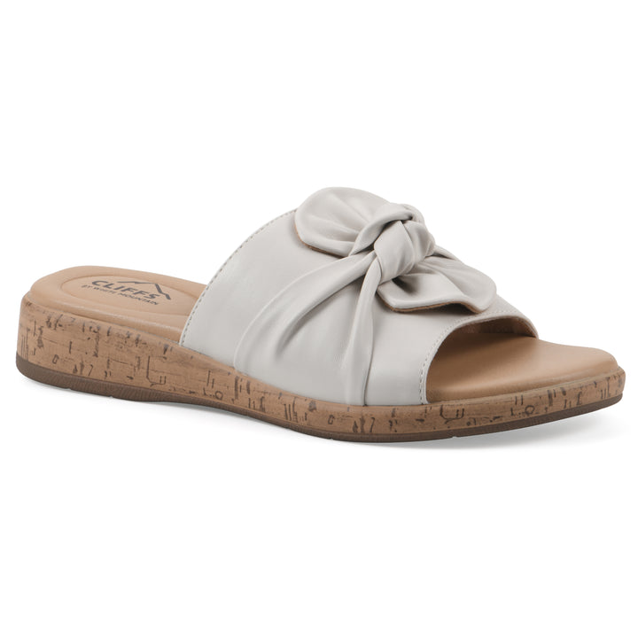 Angle view of a white faux leather sandal with centered twist, and cork-print sole design