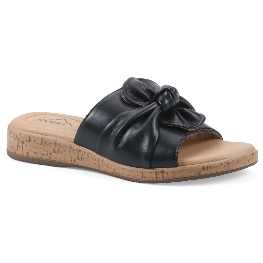 Angle view of a black faux leather sandal with centered twist, and cork-print sole design