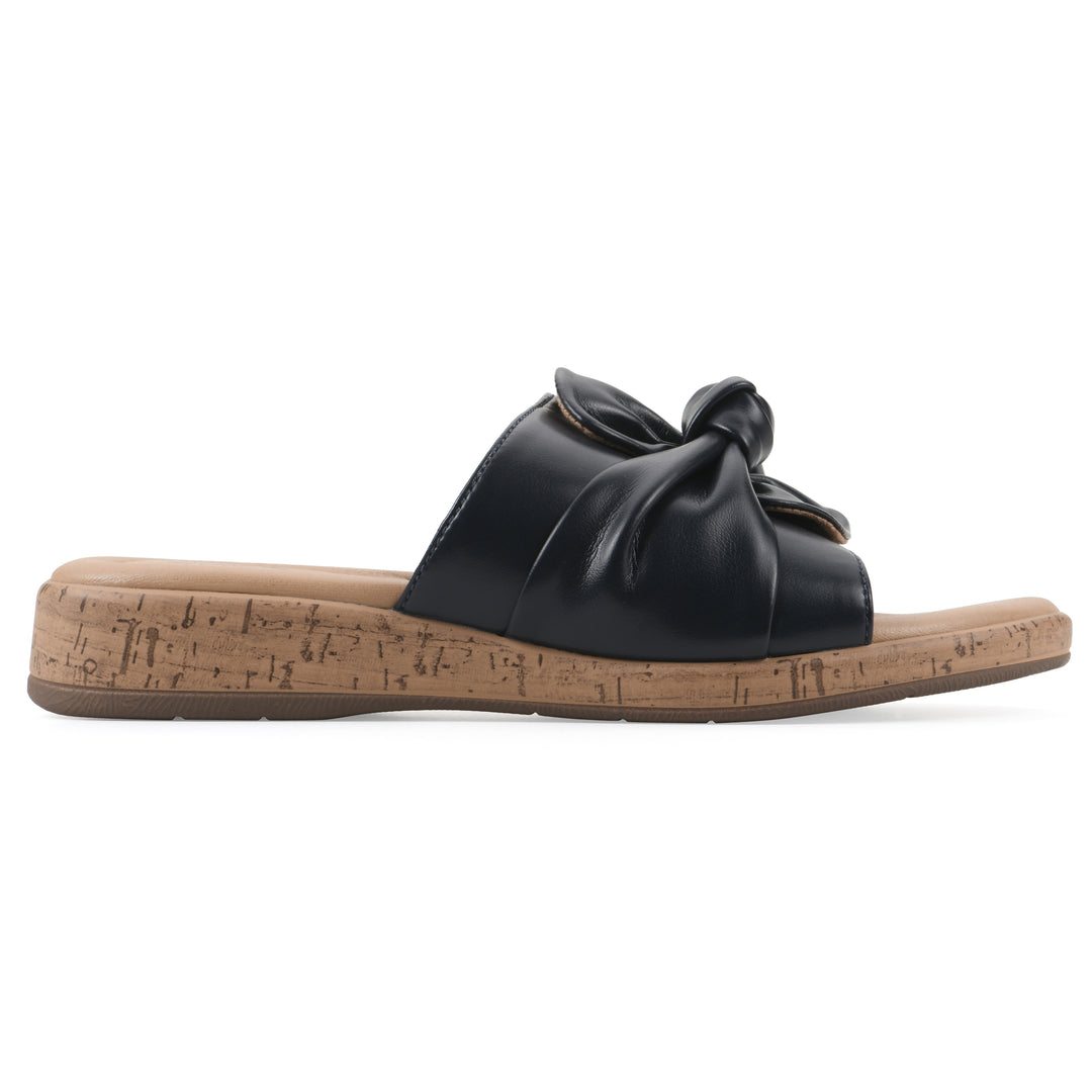 Side view of a black faux leather sandal with centered twist, and cork-print sole design