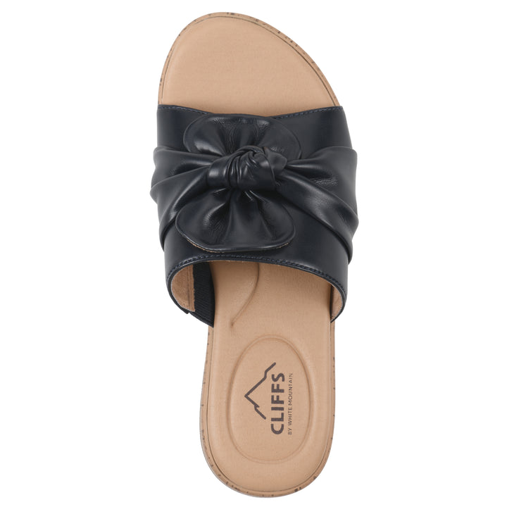 Top view of a black faux leather sandal with centered twist, and cork-print sole design