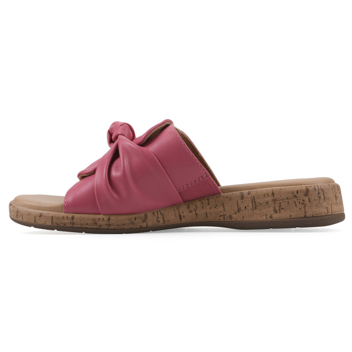 Side view of a mauve faux leather sandal with centered twist, and cork-print sole design