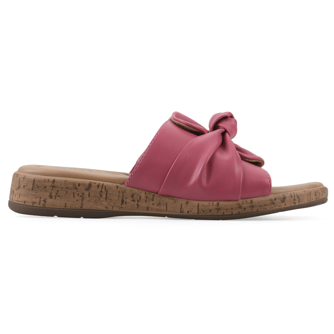 Side view of a mauve faux leather sandal with centered twist, and cork-print sole design