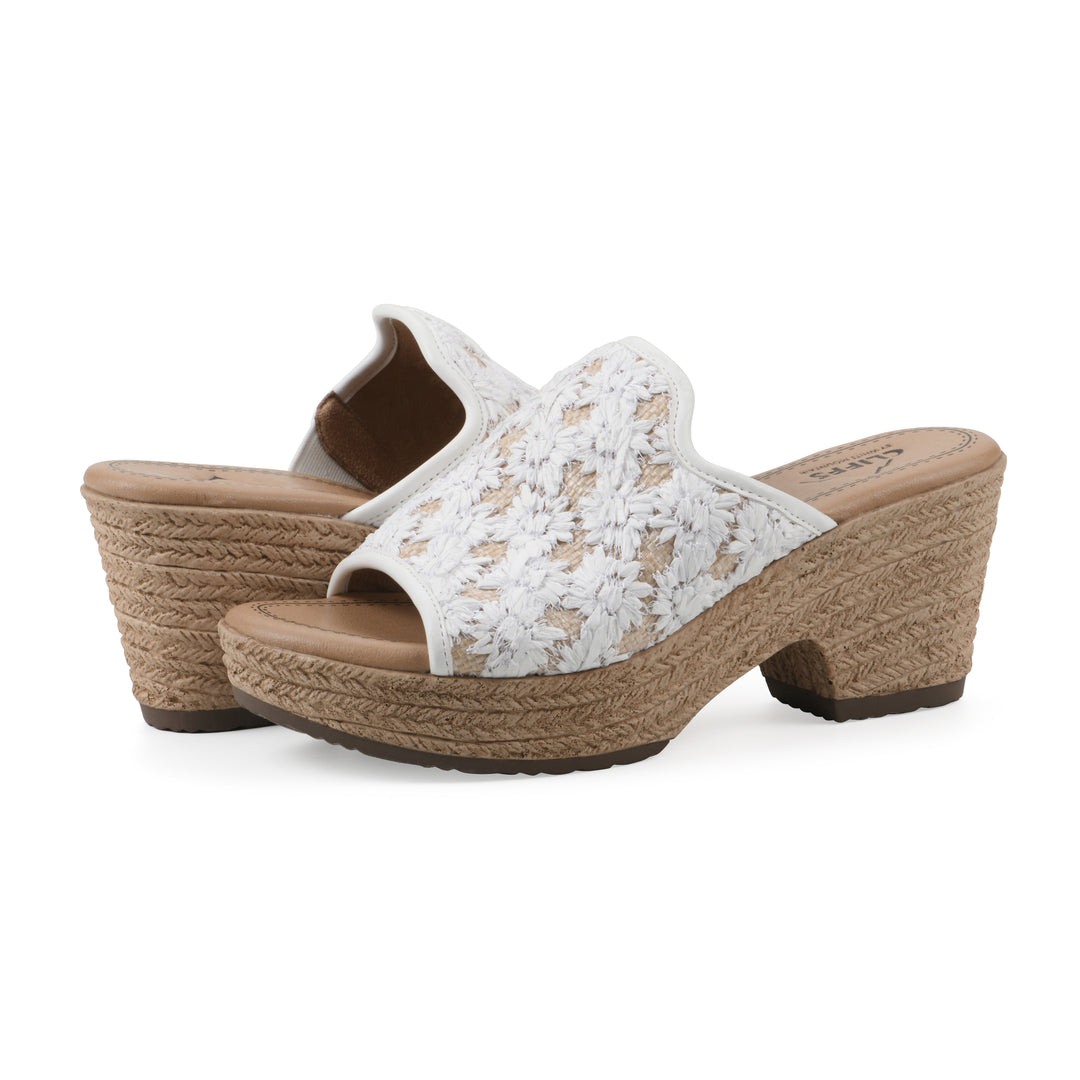 Angle view of a pair of white and natural raffia embroidered fabric wedge sandals with a braided rope-style sole