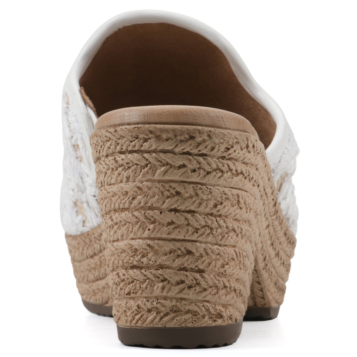 Rear view of a white and natural raffia embroidered fabric wedge sandal with a braided rope-style sole