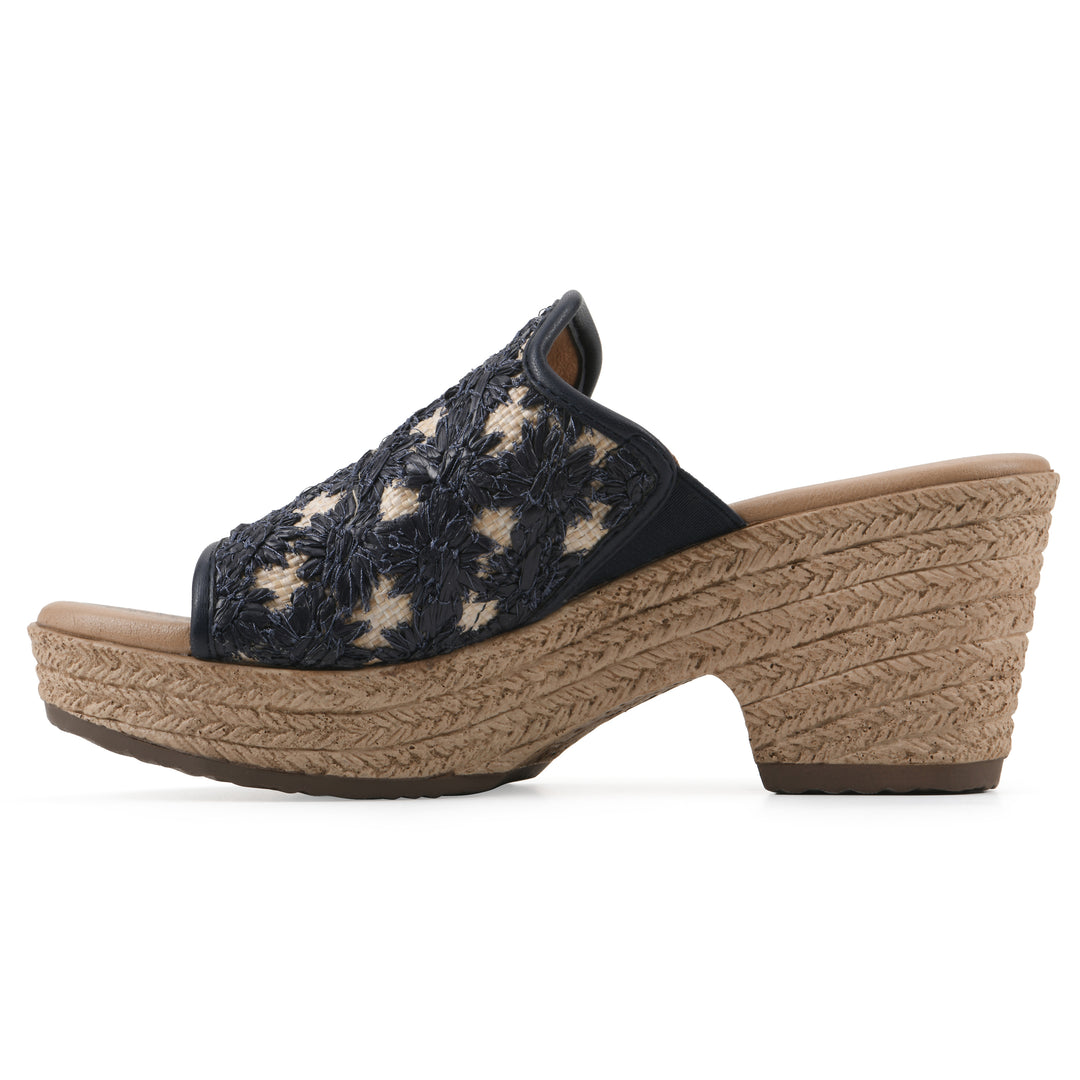 Side view of a dark blue embroidered fabric wedge sandal with a braided rope-style sole