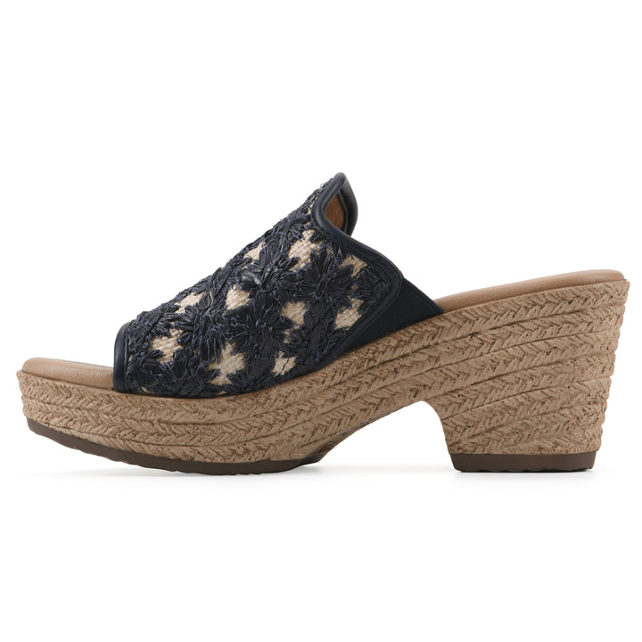 Side view of a dark blue embroidered fabric wedge sandal with a braided rope-style sole