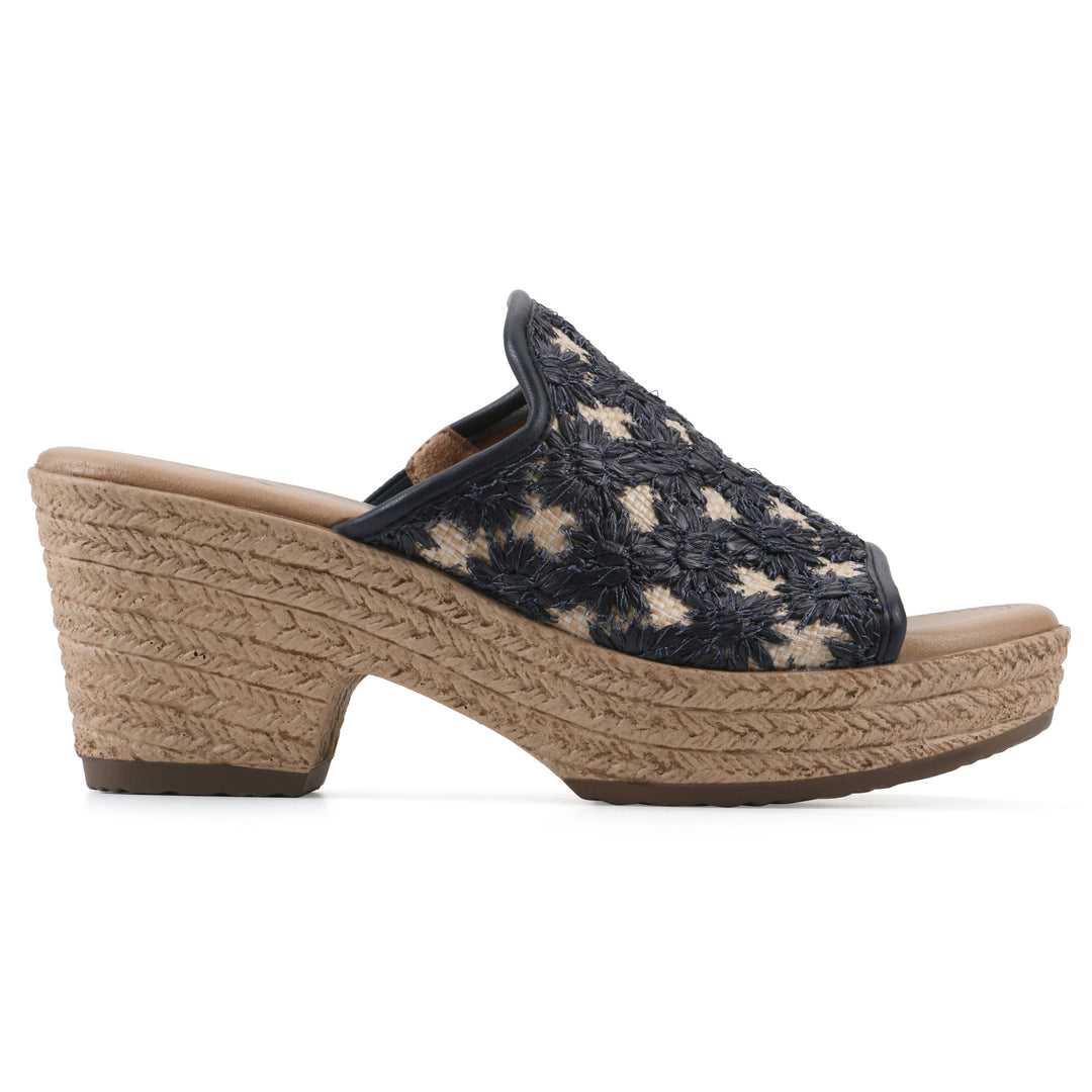 Side view of a dark blue embroidered fabric wedge sandal with a braided rope-style sole