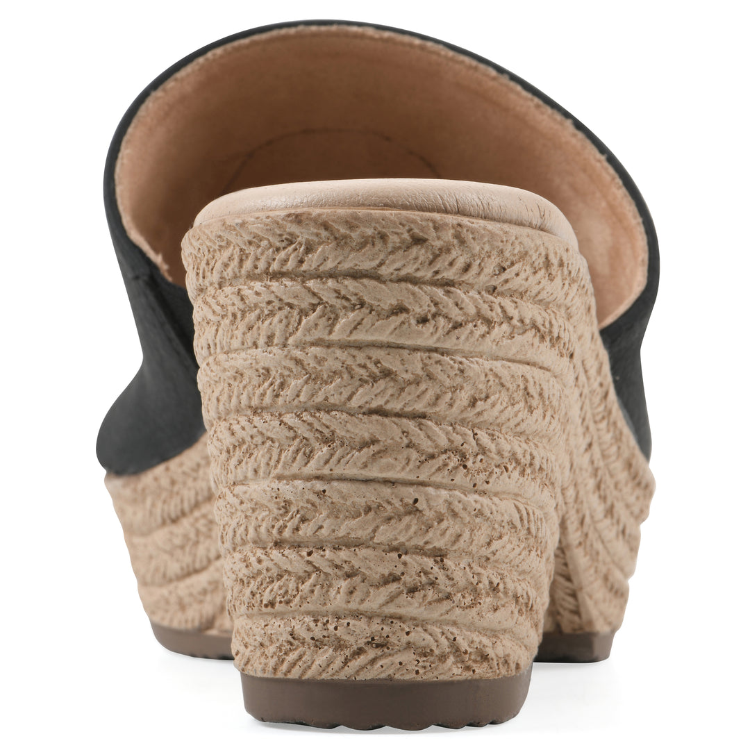 Rear view of a black, backless wedge sandal with centered sunflower embellishment, and braided rope style heel