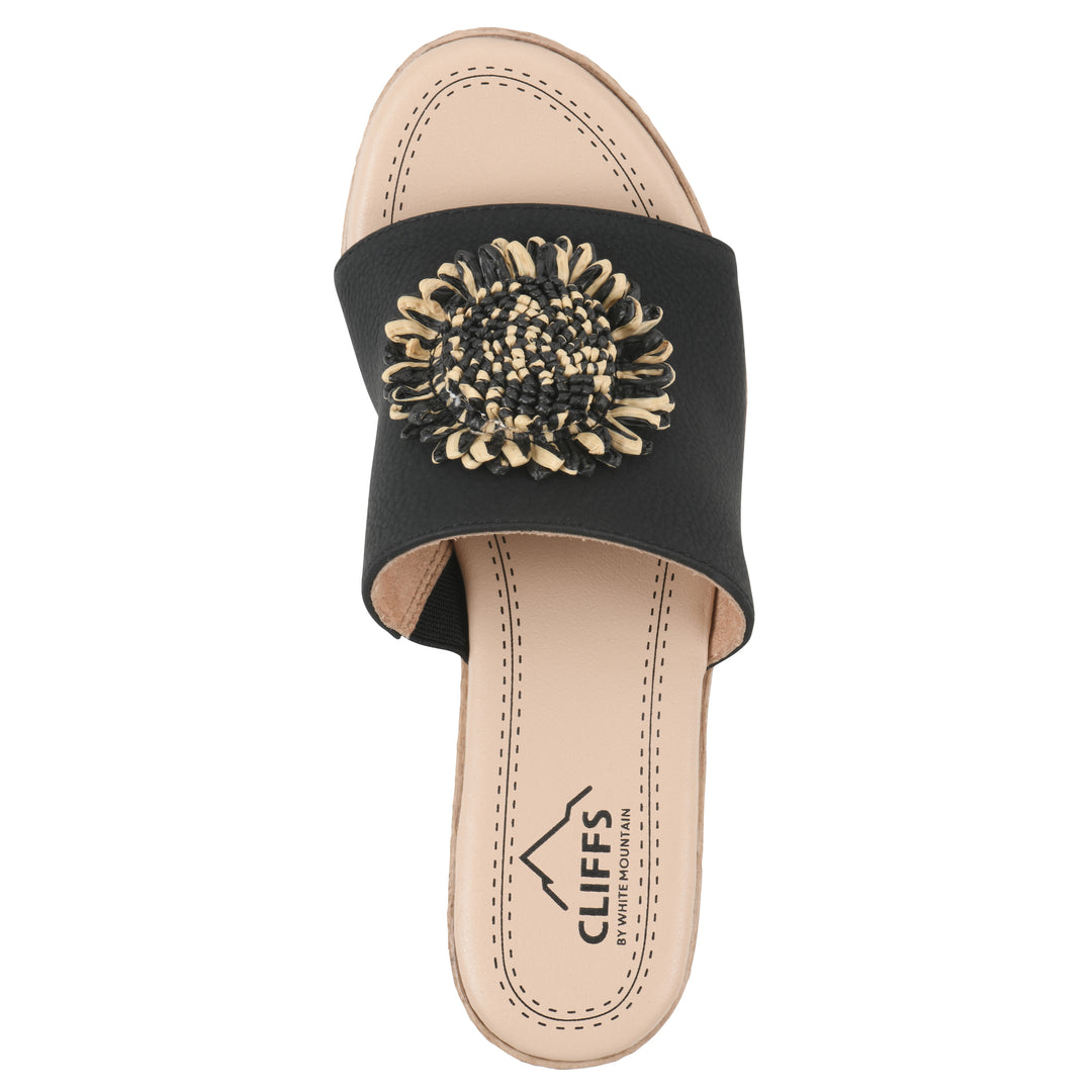 Top view of a black, backless wedge sandal with centered sunflower embellishment, and braided rope style heel