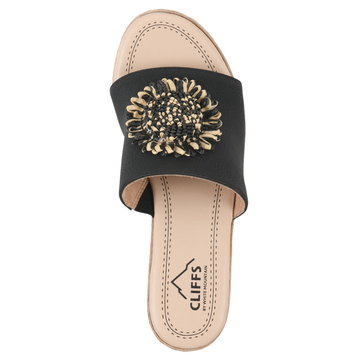 Top view of a black, backless wedge sandal with centered sunflower embellishment, and braided rope style heel