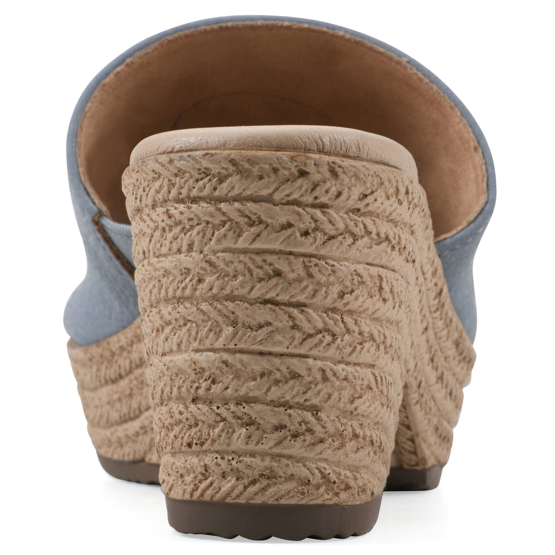 Rear view of a blue, backless wedge sandal with centered sunflower embellishment, and braided rope style heel