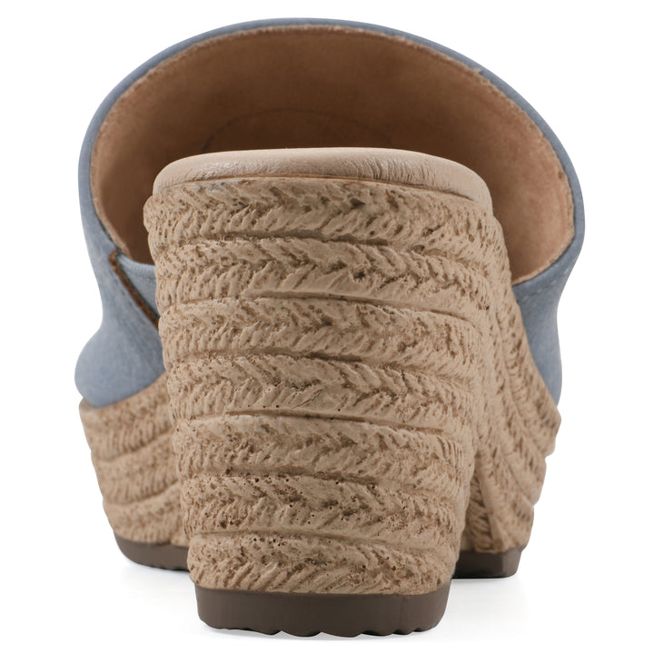 Rear view of a blue, backless wedge sandal with centered sunflower embellishment, and braided rope style heel