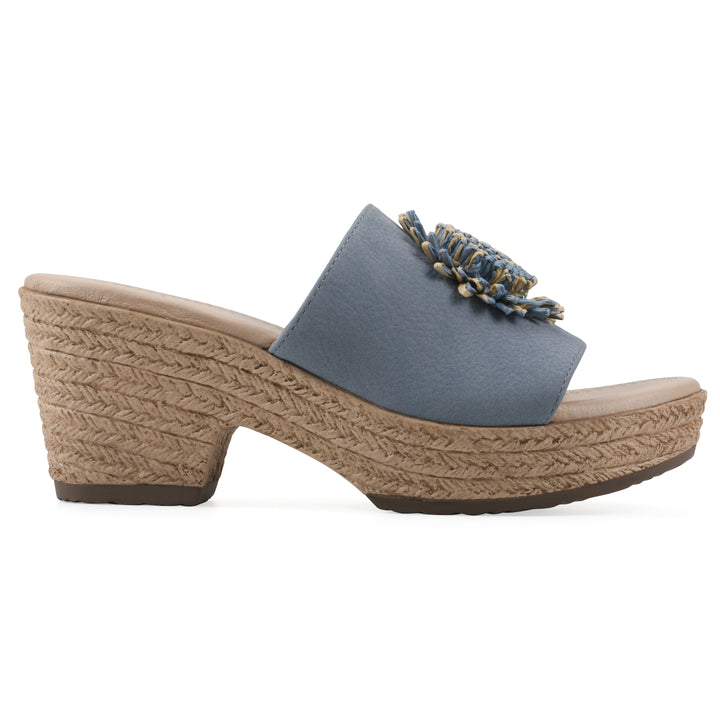 Side view of a blue, backless wedge sandal with centered sunflower embellishment, and braided rope style heel
