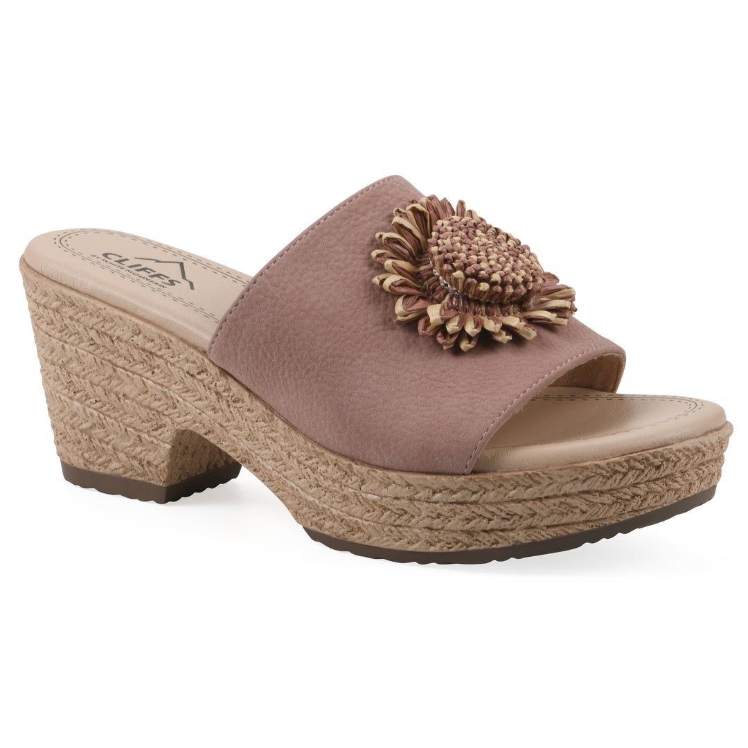 Angle view of a taupe, backless wedge sandal with centered sunflower embellishment, and braided rope style heel