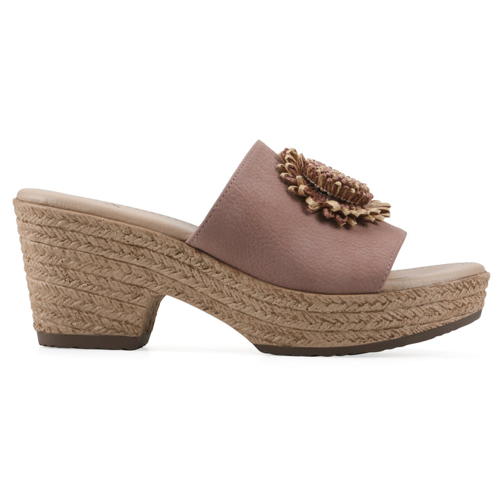 Side view of a taupe, backless wedge sandal with centered sunflower embellishment, and braided rope style heel