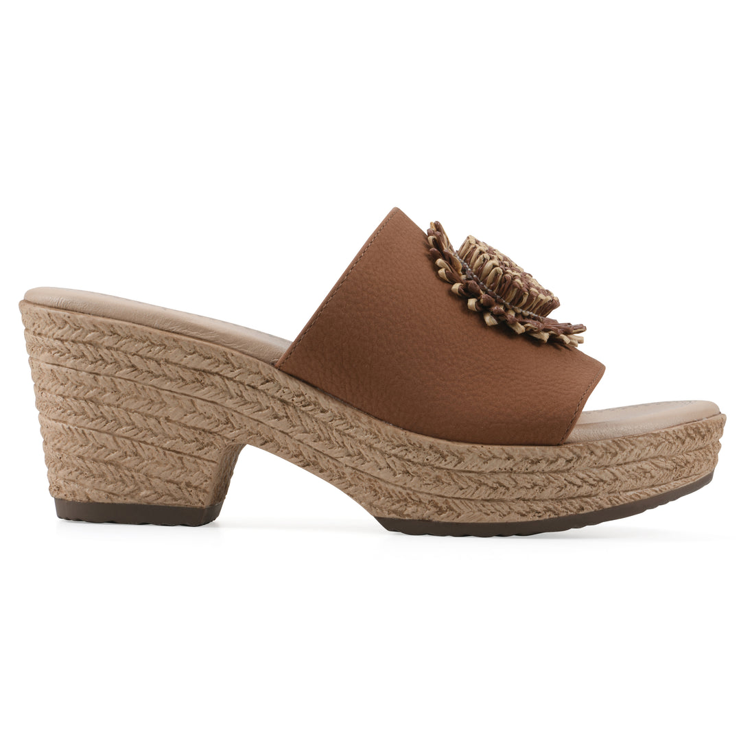 Side view of a brown, backless wedge sandal with centered sunflower embellishment, and braided rope style heel