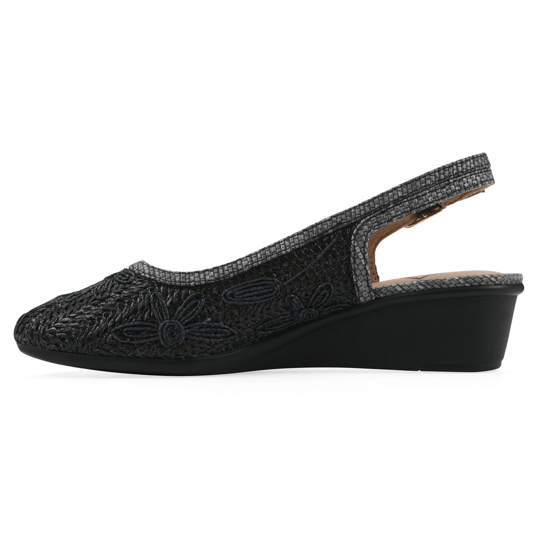Side view of a woven, black, raffia slingback with black floral detailing and an adjustable heel strap