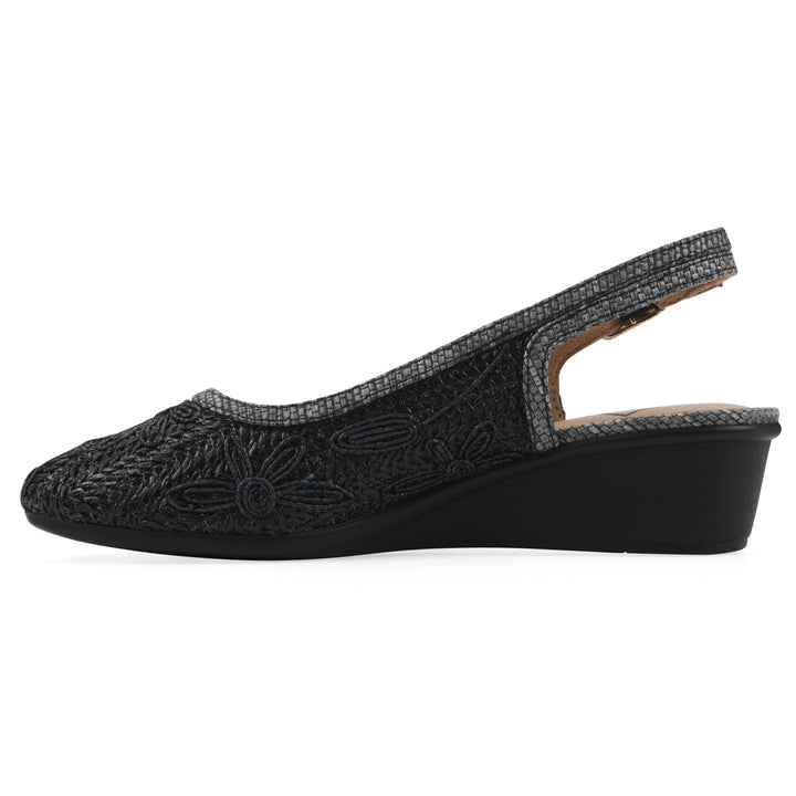 Side view of a woven, black, raffia slingback with black floral detailing and an adjustable heel strap