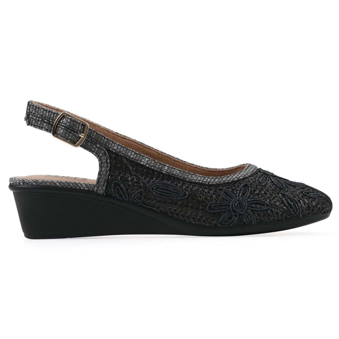Side view of a woven, black, raffia slingback with black floral detailing and an adjustable heel strap