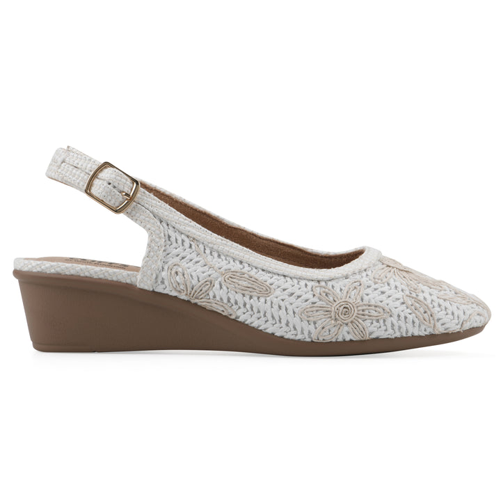 Side view of a woven, white, raffia slingback with white floral detailing and an adjustable heel strap