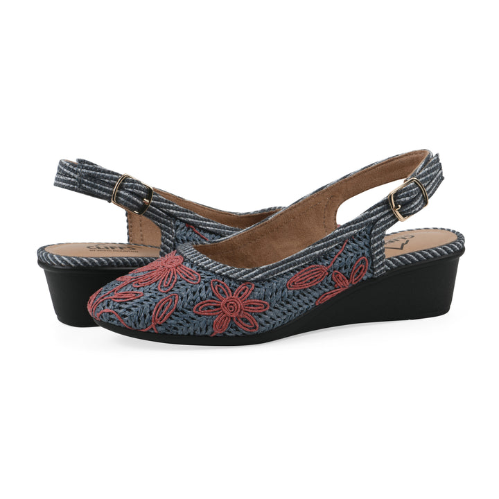 Angle view of a pair of woven, blue, raffia slingbacks with muted red floral detailing and an adjustable heel strap