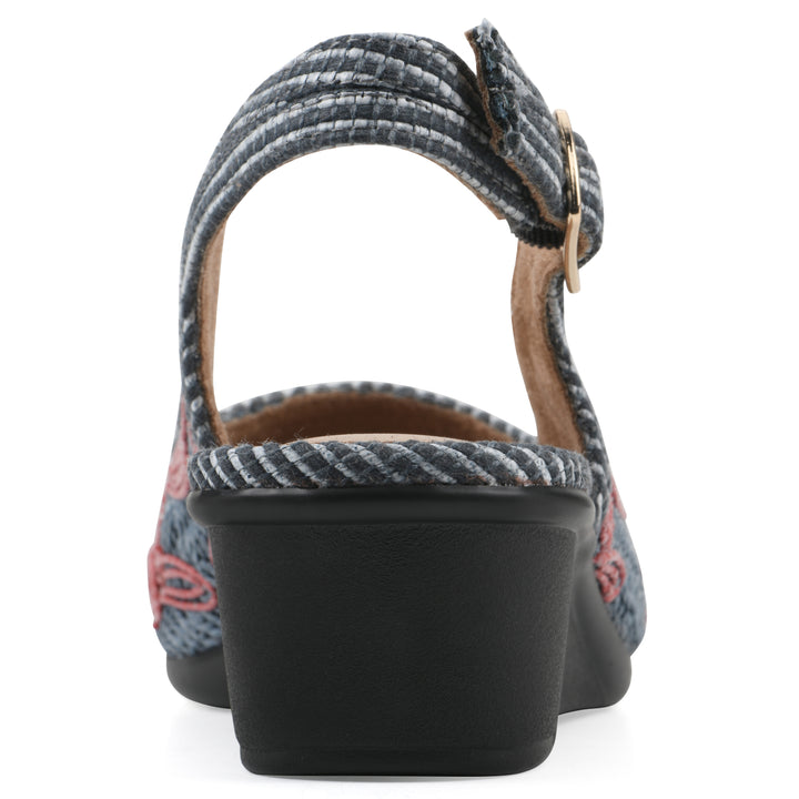 Rear view of a woven, blue, raffia slingback with muted red floral detailing and an adjustable heel strap